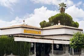Fachada exterior del Kiosco de las Flores con terraza y palmeras