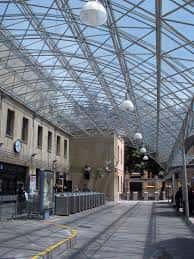 Interior de la estación con techo de cristal y estructura metálica