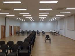 Gran salón de actos con iluminación moderna y disposición flexible para reuniones