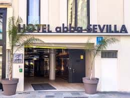 Entrada principal del Hotel Abba Sevilla con palmeras decorativas