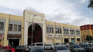 Vista exterior del Mercado de Pino Montano con fachada amarilla y entrada arqueada