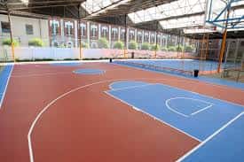 Pista de pádel interior con superficie de colores y vallas de cristal