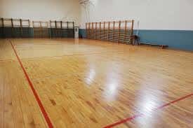 Pabellón deportivo con suelo de madera y gradas plegables