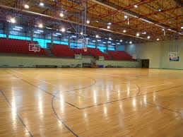 Pabellón deportivo con gradas rojas y canastas de baloncesto
