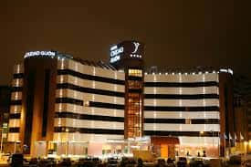 Vista nocturna del Hotel Silken Ciudad de Gijón con fachada iluminada