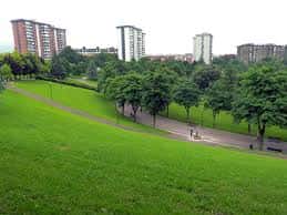 Amplia zona de césped con senderos y edificios residenciales en el horizonte
