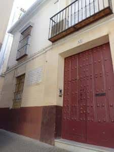 Fachada principal con puerta de madera y balcón