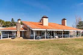 Edificio principal del camping con terraza y chimeneas de ladrillo