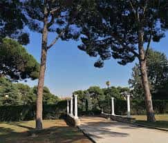 Entrada al Jardín de Invierno con columnas clásicas y árboles altos