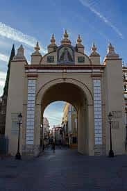 Arco de entrada a la Plaza de San Gabriel con detalles arquitectónicos y cielo despejado