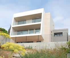 Edificio contemporáneo con balcones y fachada de hormigón y madera