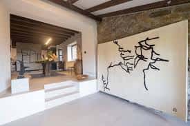 Espacio expositivo con escalones y una instalación artística en la pared