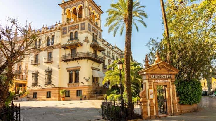 Fachada histórica del edificio principal con estilo arquitectónico andaluz y palmeras
