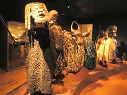 Colección de máscaras y vestimentas tradicionales africanas en exhibición