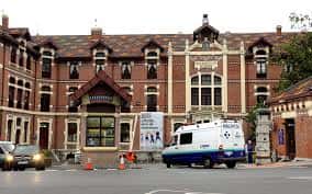 Entrada principal del edificio de gobierno del hospital con ambulancia en primer plano
