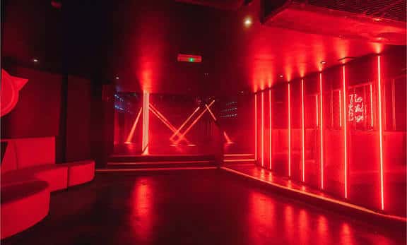 Interior del Club Revenge con iluminación roja y escenario