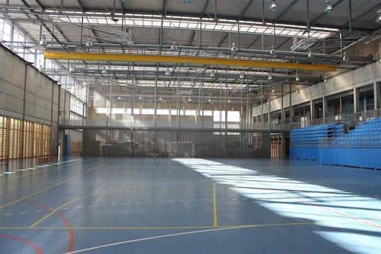 Vista del gimnasio principal del polideportivo con gradas azules