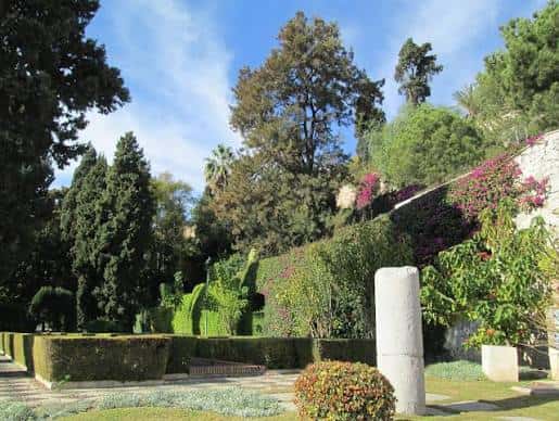 Paisaje de los jardines con columnas romanas y vegetación mediterránea