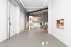 Vista interior de la galería Balazsi con obras de arte en las paredes