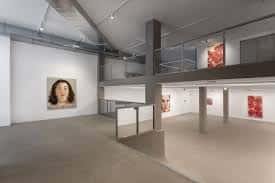 Espacio expositivo de la galería con obras de arte y estructura de dos niveles