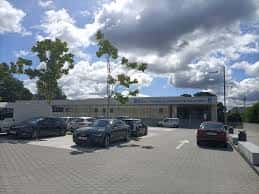 Vista exterior de la Estación de Autobuses de Pontevedra con aparcamiento y cielo parcialmente nublado