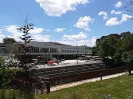 Fachada oeste de la estación de autobuses con vegetación y vías en primer plano