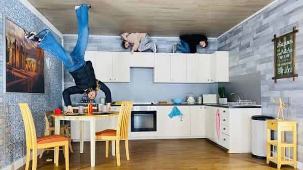 Interior de la cocina invertida con personas colgando del techo