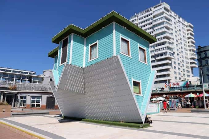 Vista exterior de la casa invertida en Brighton con cielo azul