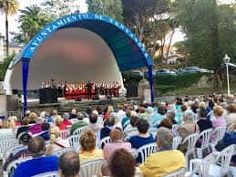 Auditorio Los Carabelas con coro en escena y espectadores