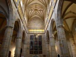 Interior de la iglesia mostrando bóvedas góticas y columnas de piedra