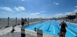 Vista panorámica de la piscina al aire libre de Sea Lanes con el mar al fondo