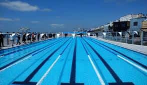 Pista de natación al aire libre con carriles marcados y cielo despejado