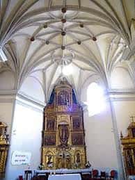 Interior de la Iglesia de San Juan Bautista con bóveda de crucería y retablo dorado