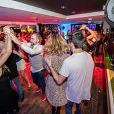 Parejas bailando en el salón principal de La Casa de la Música con iluminación ambiental