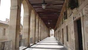 Pasillo cubierto de Los Arquillos mostrando la estructura de arcos y techo de madera