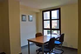 Sala de trabajo con mesa y sillas giratorias