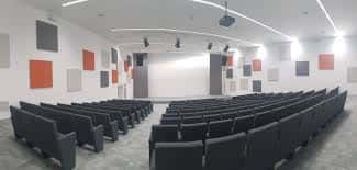 Sala de eventos con butacas modernas y sistema de iluminación profesional
