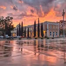 Fachada del Centro Cívico Estación del Norte al atardecer con reflejos en el suelo mojado