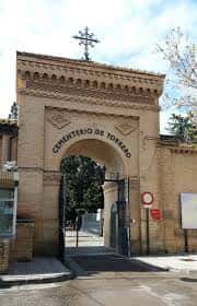 Entrada principal del Cementerio de Torrero con arco de piedra y cruz en la parte superior