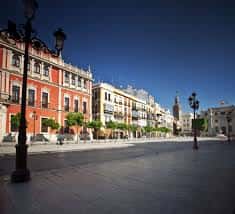 Vista diurna de la Plaza de San Francisco con edificios históricos y farolas clásicas