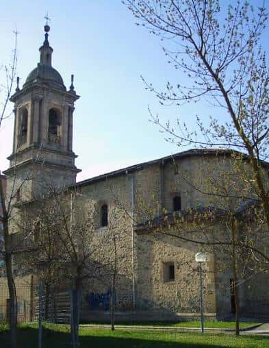 Vista exterior de la Iglesia de San Vicente de Arriaga con su torre campanario y fachada de piedra