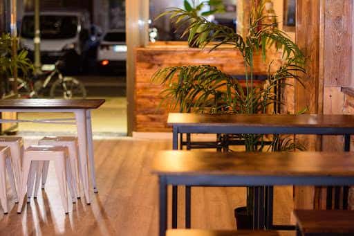 Interior acogedor del Bar Elizondo con mesas de madera y plantas decorativas