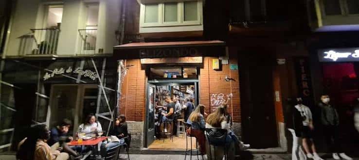 Fachada nocturna del Bar Elizondo con clientes disfrutando en la terraza