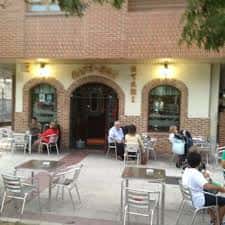 Terraza exterior del café con mesas y clientes