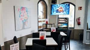 Sala interior con mesas, TV y decoración artística