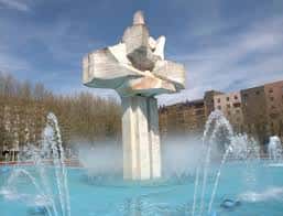 Monumento central de la plaza con fuente y cielo despejado