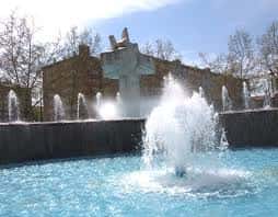 Detalle de la fuente principal con agua en movimiento y fondo urbano