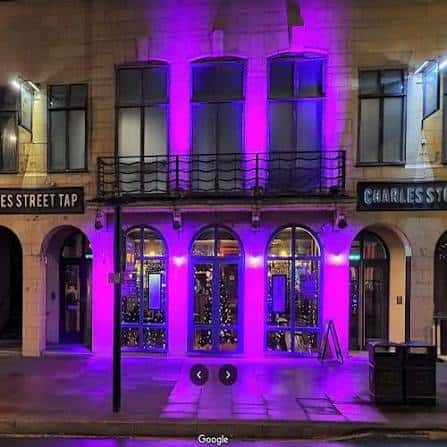 Fachada exterior del Charles Street Tap iluminada con luces de neón morado