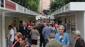 Pasillos llenos de visitantes entre las casetas de la feria
