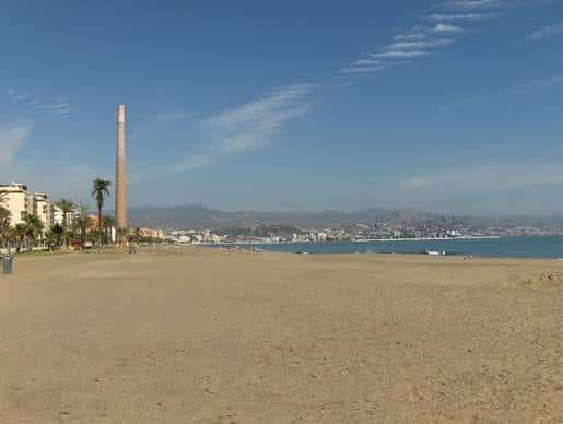 Vista panorámica de la Playa de la Misericordia con el icónico tubo de la factoría en el horizonte